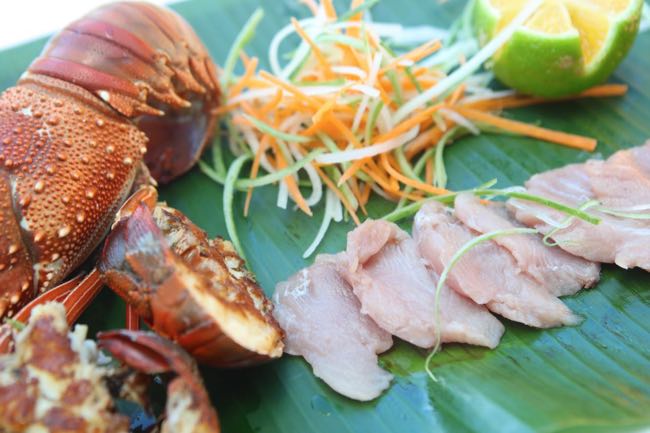 “Fresh seafood platter in Fiji featuring lobster and sashimi, beautifully presented with vibrant colors. A perfect showcase o